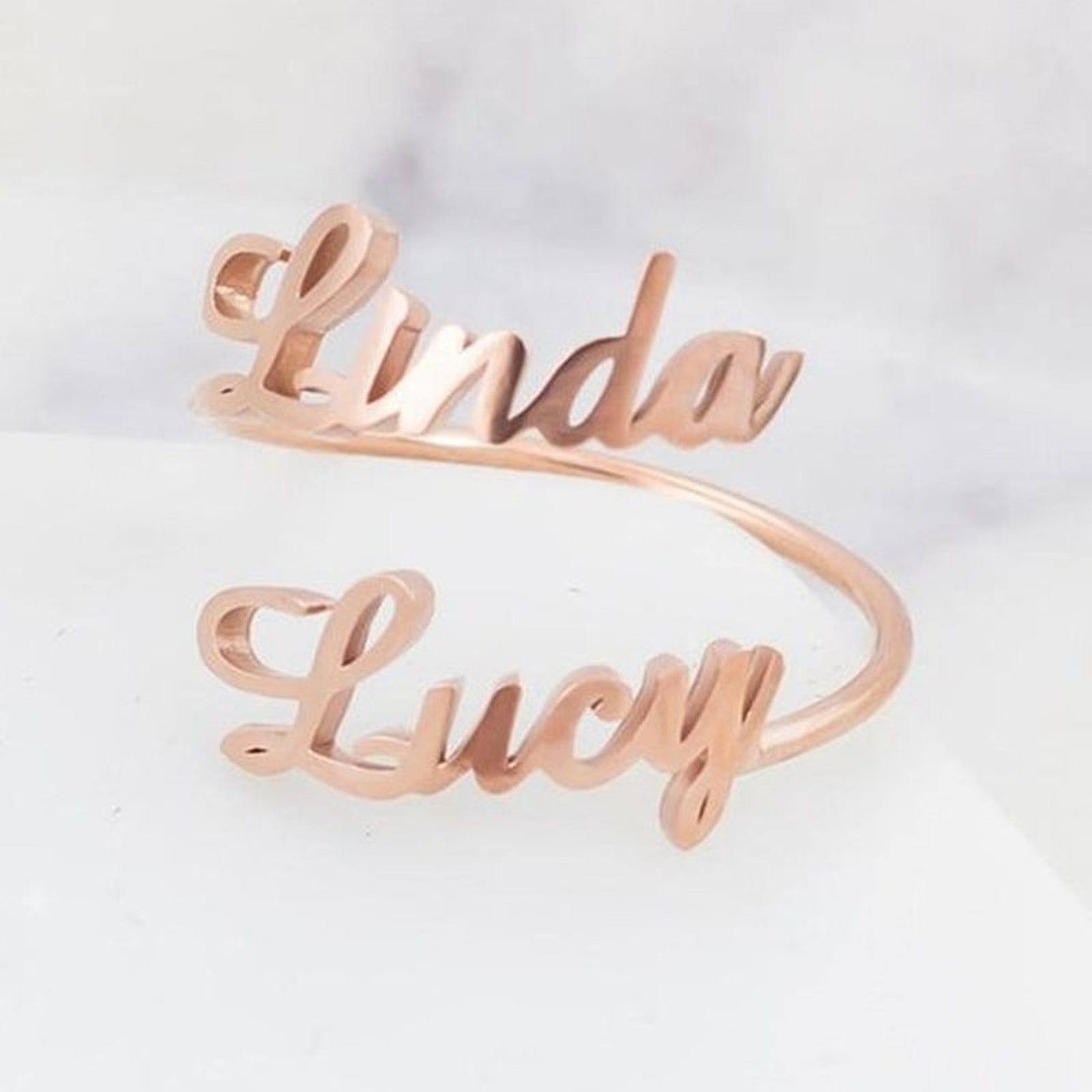 A rose-gold ring that spells two names, Linda and Lucy